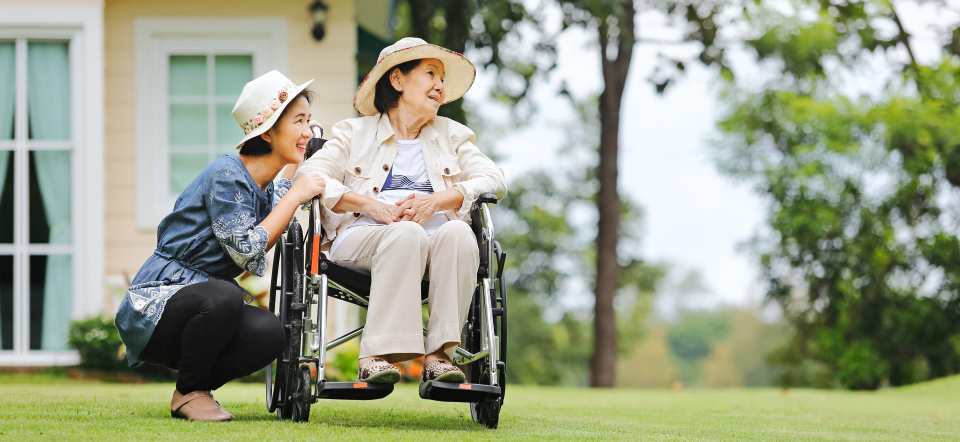 a woman and an elder lady on the wheelchair outdoors